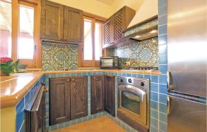 eine Küche mit Holzschränken, einer Waschmaschine und einem Trockner in der Unterkunft Villa Anna in Menfi