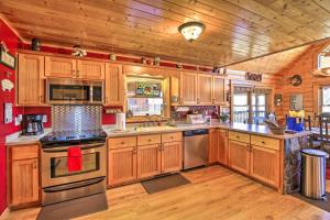 eine große Küche mit Holzschränken und Küchengeräten aus Edelstahl in der Unterkunft River Dream Cabin on New River with Deck, Fire Pit in Piney Creek
