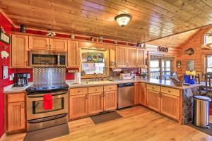 a large kitchen with wooden cabinets and stainless steel appliances at 'River Dream Cabin' on New River w/ Fire Pit in Piney Creek