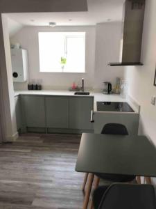 a kitchen with a table and a sink and a window at Goring Beach Studio - 2 min walk from seafront in Goring by Sea