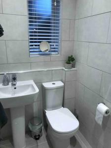 Baño blanco con aseo y lavamanos en Goring Beach Studio - 2 min walk from seafront, en Goring by Sea