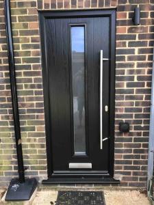 a black door on the side of a brick building at Goring Beach Studio - 2 min walk from seafront in Goring by Sea