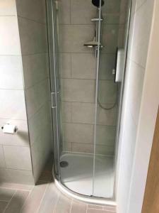 a shower with a glass door in a bathroom at Goring Beach Studio - 2 min walk from seafront in Goring by Sea