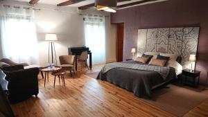 1 dormitorio con cama, escritorio y piano en Gîtes & Chambres d'hôtes Peyrecout en Laparrouquial