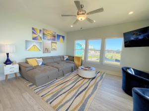 a living room with a couch and a ceiling fan at 1 Naut On Call home in Crystal Beach