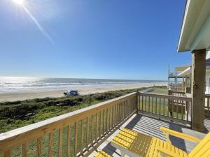 a house with a deck with a view of the beach at 1 Naut On Call home in Crystal Beach