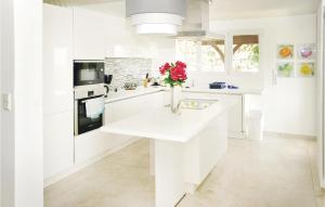 une cuisine blanche avec un vase de fleurs sur un comptoir dans l'établissement Cozy Home In Seillans With Kitchen, à Seillans