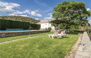 a backyard with a table and chairs and a pool at Stunning Home In Rute With 9 Bedrooms And Outdoor Swimming Pool in Rute
