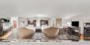 a hotel room with two beds and a flat screen tv at Suburban Studios Mason Hwy 42 in Mason