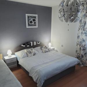 Un dormitorio con una cama grande y una lámpara de araña. en Apartmán ZUZKA en Veľká Lomnica