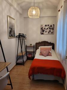 a bedroom with a bed with a red blanket at Piso Stylety Casco Antiguo in Talavera de la Reina