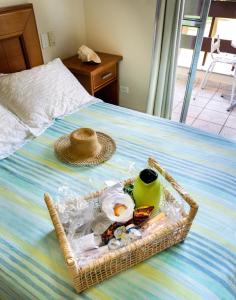 a basket of food and a hat on a bed at Costabela Apart Hotel e Pousada in Ilhabela +50 photos