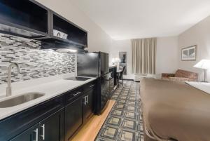 a kitchen with a sink and a couch in a room at Suburban Studios Mason Hwy 42 in Mason