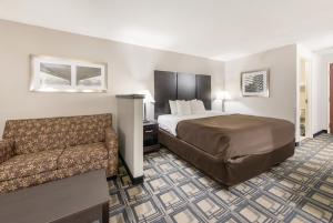 a hotel room with a bed and a couch at Suburban Studios Mason Hwy 42 in Mason