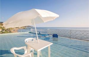 a table and chairs with an umbrella and the ocean at Apt, Riviera Blu in Diamante