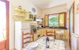 a kitchen with a table and a white refrigerator at Casa Della Margherita in Camaiore