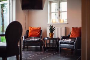 a living room with two chairs and a table at Larchfield Grange, Luxury House with Stunning Views in Abergavenny