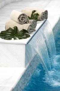 a water slide in a pool with towels and a waterfall at Emperador in Madrid
