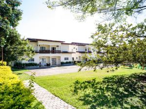 a building with a grassy yard in front of it at Costabela Apart Hotel e Pousada in Ilhabela