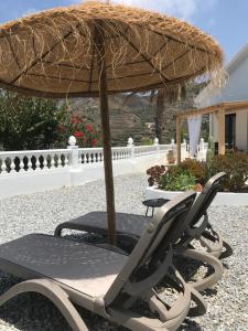 - une chaise sous un parasol en paille sur la terrasse dans l'établissement Casa Olivo, à Almuñécar