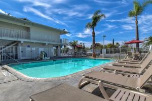 a swimming pool with lounge chairs and a resort at Motel 6-Stanton, CA in Stanton