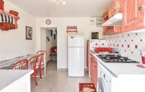 a kitchen with a stove and a white refrigerator at Stunning Home In St Avaugourd Des Lande in Saint-Avaugourd-des-Landes