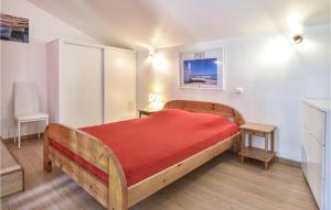 a bedroom with a wooden bed with a red blanket at Stunning Home In St Avaugourd Des Lande in Saint-Avaugourd-des-Landes +8 photos