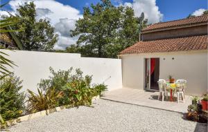 a garden with a table and chairs in front of a house at Stunning Home In St Avaugourd Des Lande in Saint-Avaugourd-des-Landes