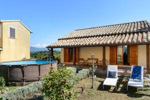 a house with a pool and two chairs in front of it at Villa Raniero Gatti in San Michele in Teverina +23 photos