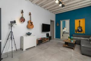 a living room with guitars on the wall at Milos Guesthouse in Triovasálos
