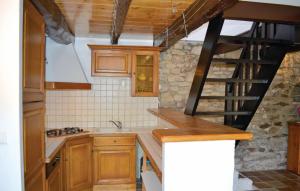 a kitchen with wooden cabinets and a spiral staircase at Holiday Home Plozevet 59 in Plozévet