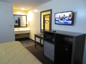 Habitación de hotel con cama y TV en la pared en Brick Motor Inn, en Brick