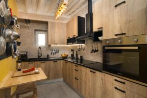 a kitchen with wooden cabinets and black appliances at Milos Guesthouse in Triovasálos