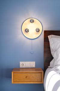 um quarto com uma luz sobre uma mesa ao lado de uma cama em Blue Moon Studio no Porto