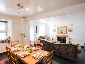 a dining room with a table and a couch at Dolwar in Amlwch