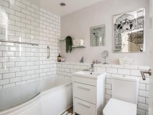 a white bathroom with a tub and a toilet and a sink at Dolwar in Amlwch +32 photos