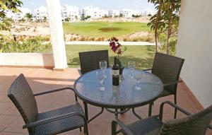 a table with wine glasses and a bottle of wine at Nice Apartment In Roldn With 2 Bedrooms, Wifi And Outdoor Swimming Pool in Las Pedreñas
