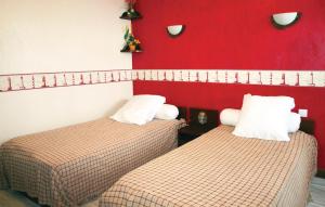 two beds in a room with a red wall at 4 Bedroom Cozy Home In Yvias in Yvias