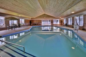 a large indoor swimming pool with a wooden ceiling at Days Inn by Wyndham Petoskey in Petoskey