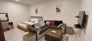 sala de estar con sofá y cama en ريف عسير للشقق المفروشة en Khamis Mushayt