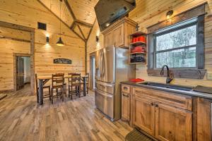 a kitchen with a sink and a table with chairs at Ouachita Mtn Home Near ATV and Hiking Trails! in Big Cedar