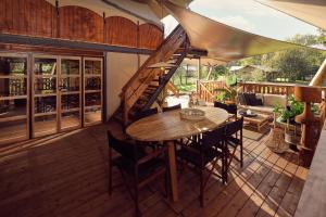 un patio con una mesa de madera y sillas en una terraza en De Parel - Mystical spaces to discover! en Zeewolde