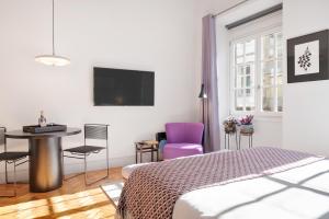 um quarto com uma cama, uma mesa e cadeiras em Blue Moon Studio no Porto
