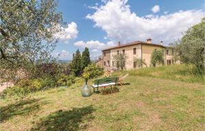 un banco del parque y un jarrón sentado en un patio en La Casina Civitella en Pieve a Maiano