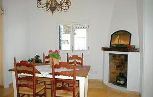Gorgeous Home In Palma De Mallorca With House Sea View في بالما دي ميورقة: غرفة طعام مع طاولة ومدفأة