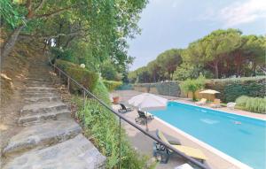 a swimming pool with an umbrella and chairs next to it at Gorgeous Home In San Feliciano Sul T,pg With House A Panoramic View in San Feliciano