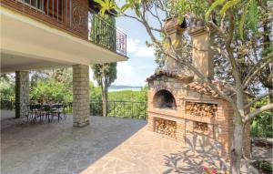 - une cheminée en briques sur la terrasse d'une maison dans l'établissement Gorgeous Home In San Feliciano Sul T,pg With House A Panoramic View, à San Feliciano