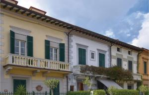 un edificio con persiane verdi e balcone di Casa Virgilio a Viareggio