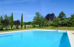 a large swimming pool in a yard with trees at Amazing Home In Gindou in Gindou +14 photos