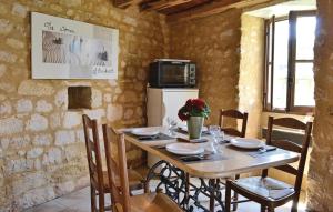 cocina con mesa de madera con sillas y nevera en Awesome Home In Cnac-et-saint-julien With Kitchen, en Cénac-et-Saint-Julien